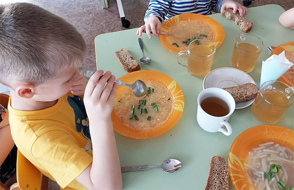 Діти їдять вирощену цибцлю в дитячому садку